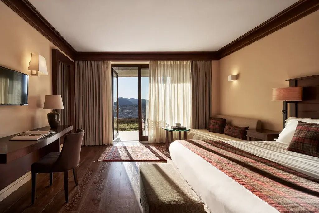 Doppel Junior-Suite mit Ausblick auf die Berge durch große Fenster