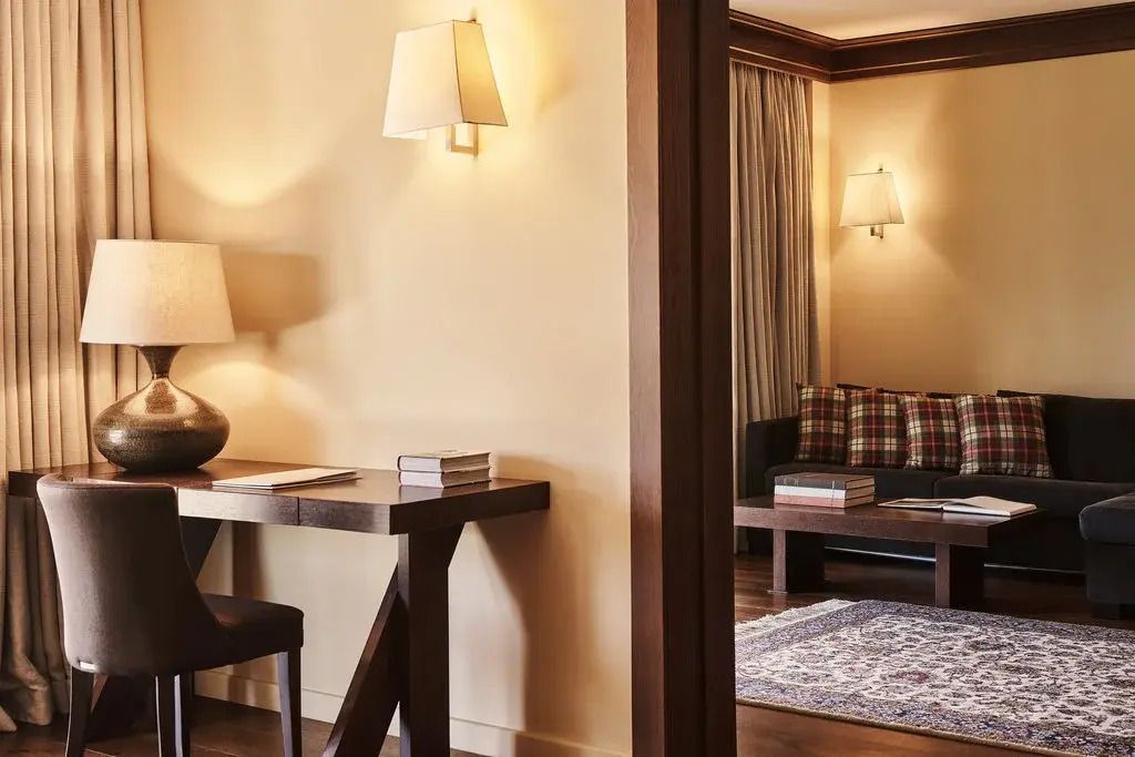 Elegantes Arbeitszimmer mit Holzschreibtisch und gemütlicher Sitzecke