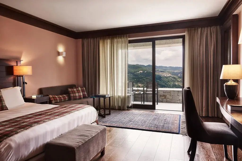 Geräumige Premium Doppel Suite mit Doppelbett und Blick auf die Berge im Grand Forest Metsovo