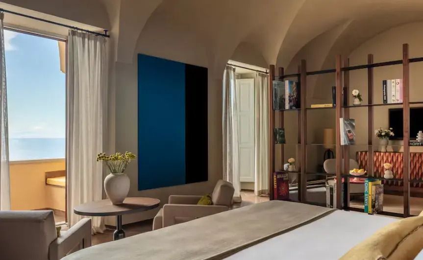 Schlafzimmer mit elegantem Kunstwerk an der Wand und Blick nach draußen.