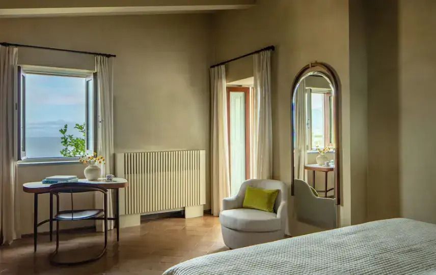 Geräumige Suite mit zwei Fenstern und elegantem Sessel.