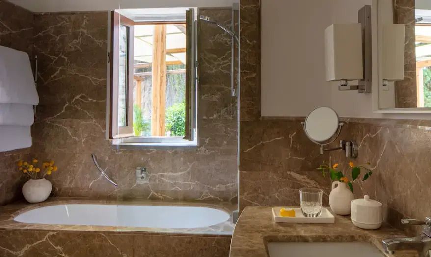 Modernes Badezimmer mit Marmorverkleidung und natürlichem Licht.