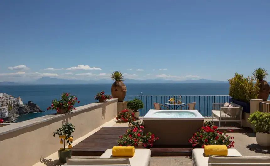 Terrasse mit Whirlpool, Liegen und Panoramablick aufs Meer