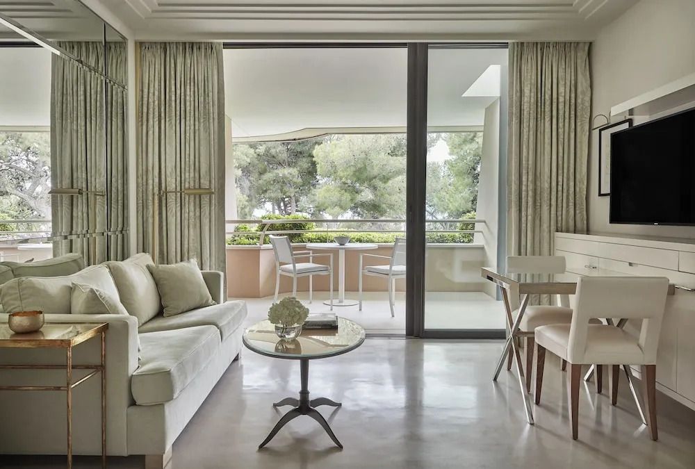 Helles Wohnzimmer mit Sofa und Esstisch, das sich zur Terrasse mit Gartenblick öffnet