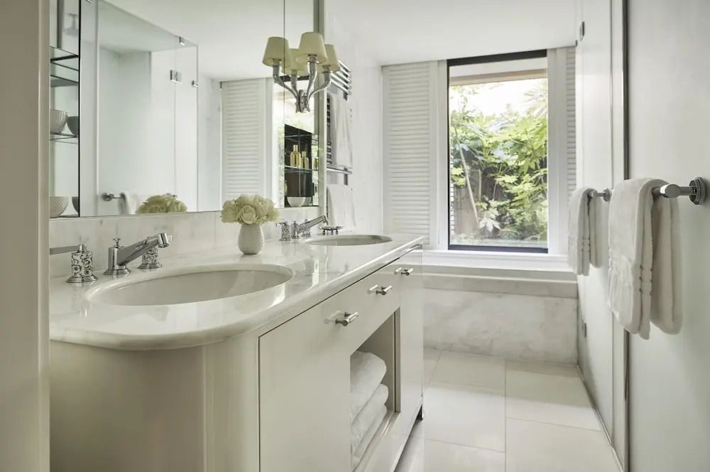 Modernes Badezimmer mit Doppelwaschbecken, Spiegel und großer Fensterfront