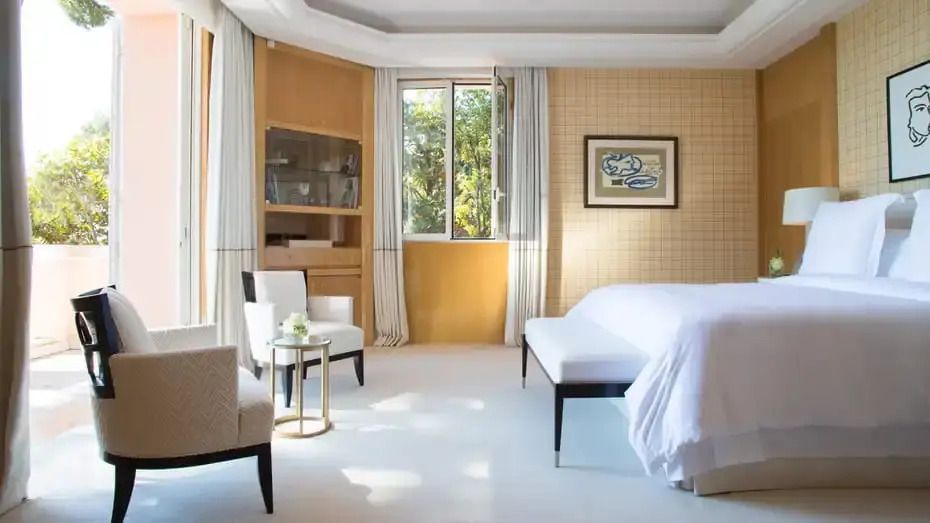 Panoramic Suite mit stilvollen Möbeln und großen Fenstern mit Blick auf den Garten.