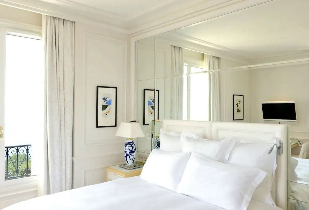 Elegantes Schlafzimmer mit Spiegelwand und blauer Tischlampe