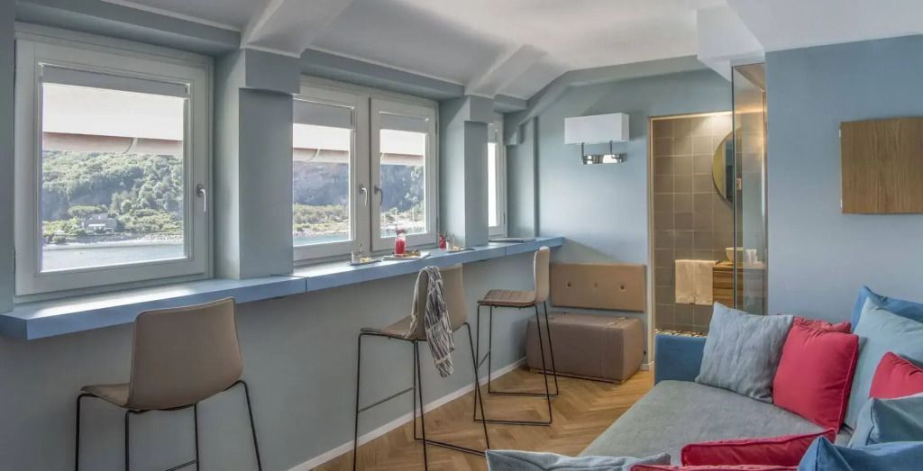 Bar mit hohen Stühlen und Fensterblick in der Dei Poeti Suite