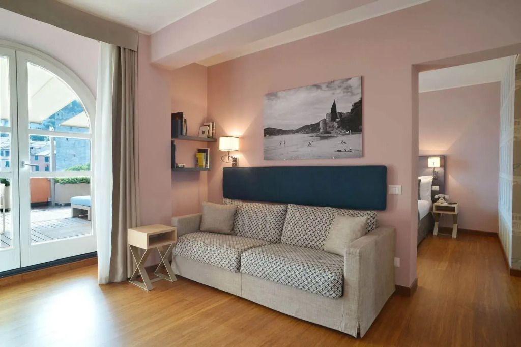Wohnbereich der Suite mit komfortablem Sofa und Kunstwerk an der Wand