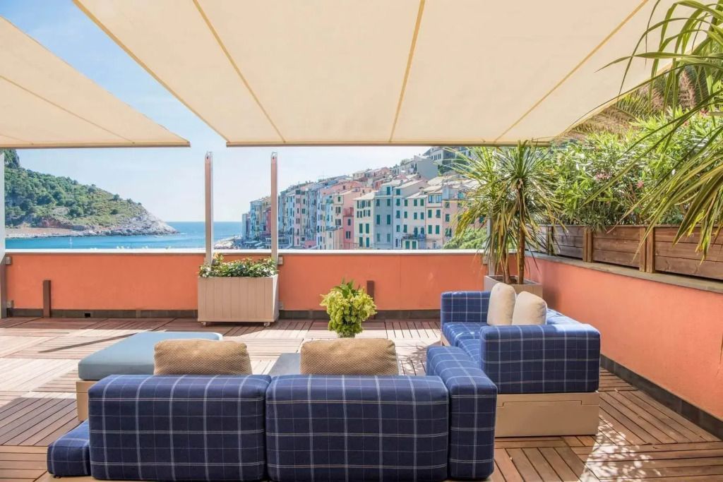 Terrasse mit Sitzmöbeln und Blick auf das bunte Küstenpanorama