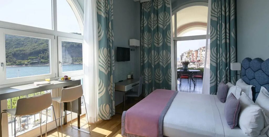Zimmer mit Doppelbett und Aussicht auf das Meer durch große Fenster