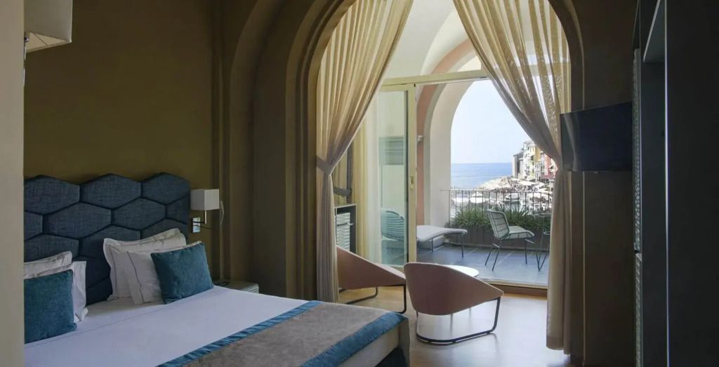 Elegantes Schlafzimmer mit öffnender Glastür zur Terrasse und Meeresblick