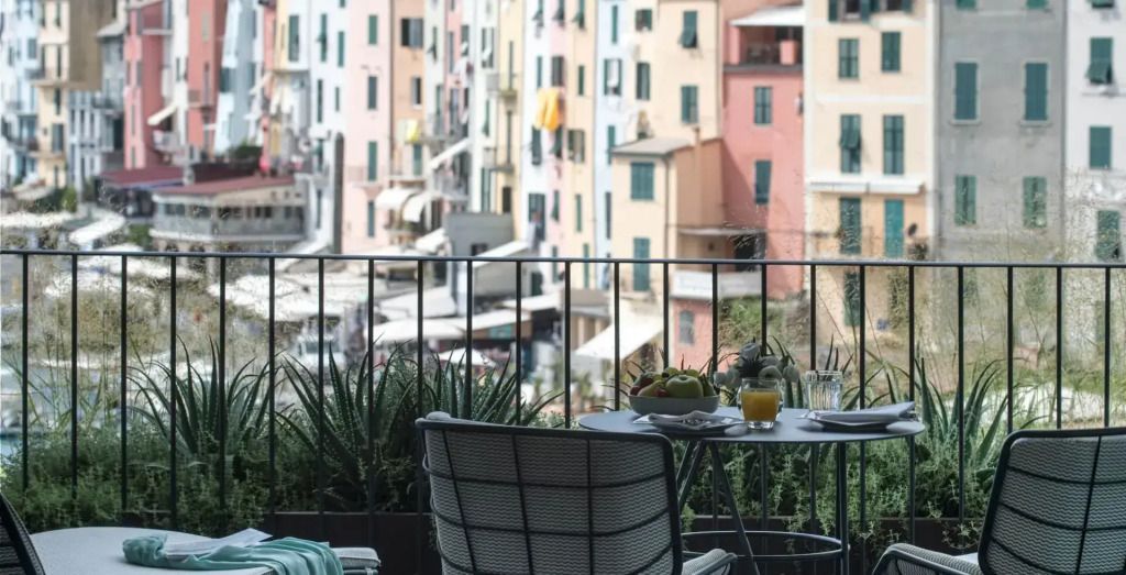 Terrasse mit Tisch und Stühlen und Blick auf die bunten Gebäude