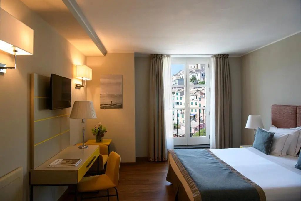 Geräumiges Doppelzimmer mit elegantem Schreibtisch und Blick auf die Stadt.