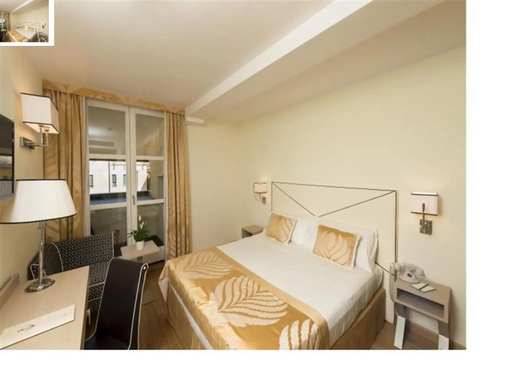 Helles Doppelzimmer mit Doppelbett und Schreibtisch im Grand Hotel Portovenere
