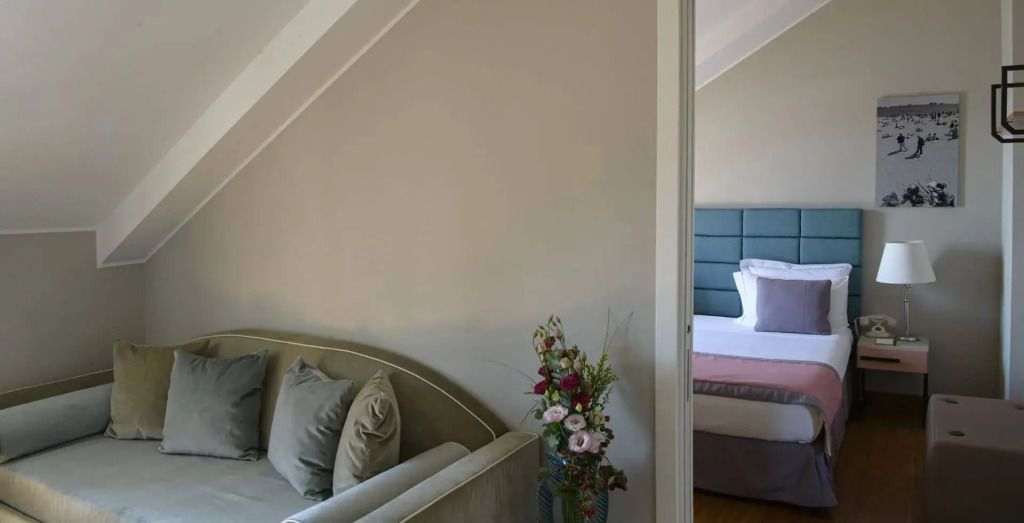 Elegantes Scriptorium Doppelzimmer mit Sofa und Blumenarrangement