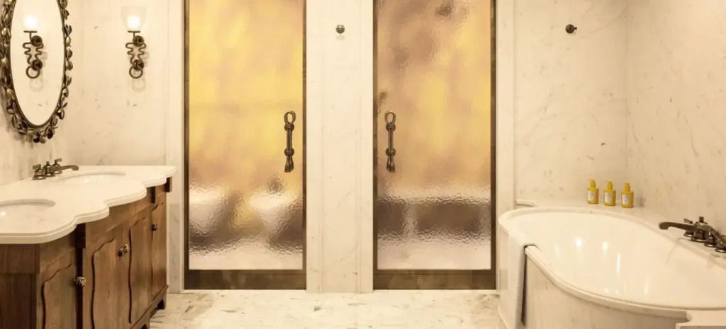 Luxuriöses Badezimmer mit stilvollen Türen und hochwertiger Ausstattung aus Marmor