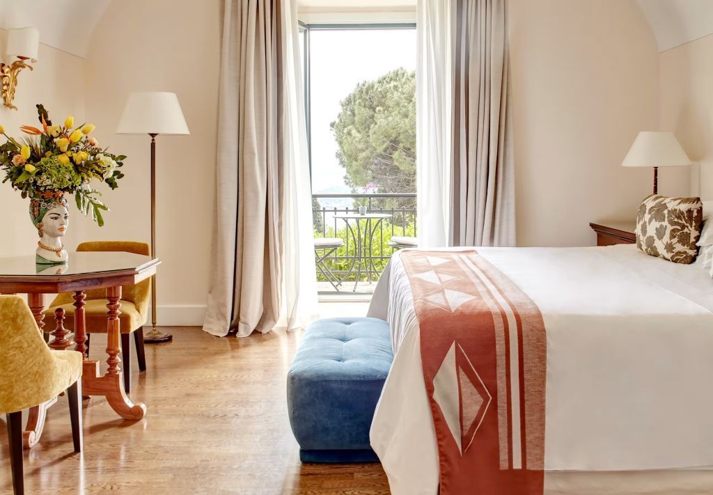 Helles Zimmer mit Doppelbett und Balkon mit Meerblick im Grand Hotel Timeo