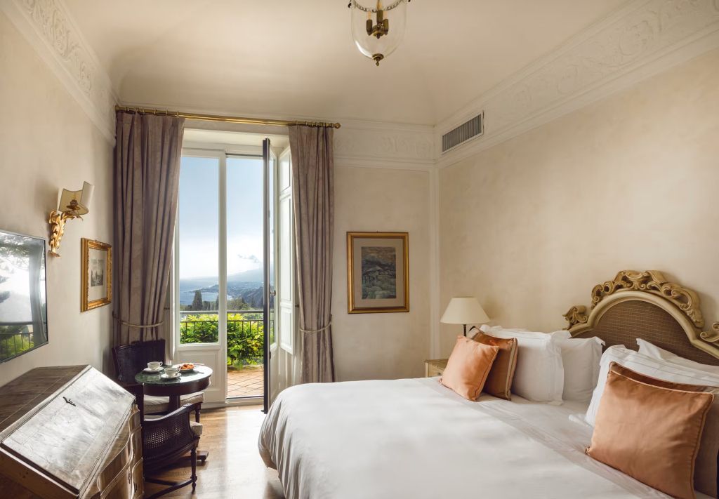 Gemütliches Schlafzimmer mit Doppelbett und Meeresblick vom Balkon