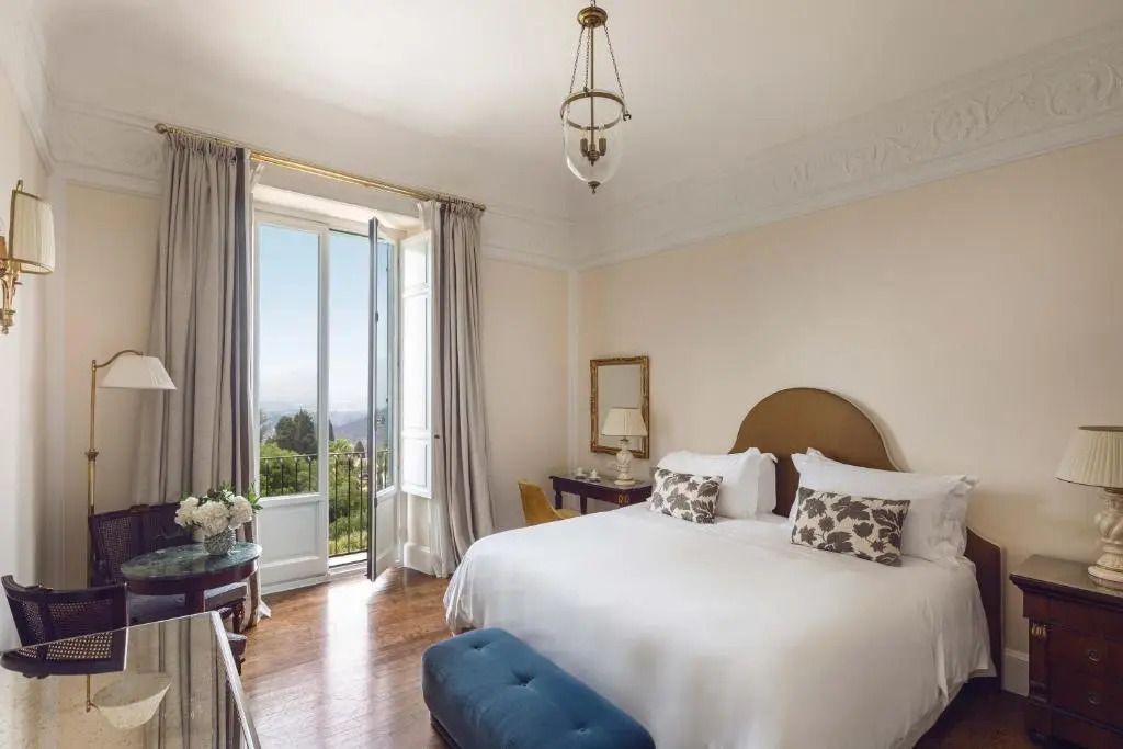 Elegantes Doppelzimmer mit großem Bett und Balkon mit Meerblick