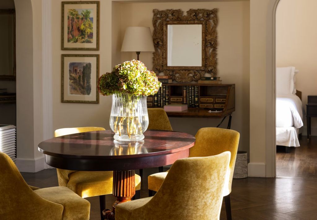 Elegantes Esszimmer mit Holztisch und modernen Stühlen, umgeben von Kunst