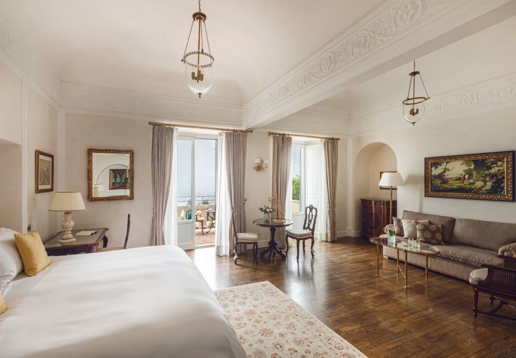 Elegantes Hotelzimmer mit geräumigem Wohnbereich und Balkon mit Meerblick