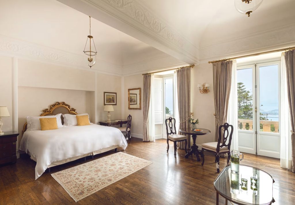 Helles Doppelzimmer mit klassischer Einrichtung und offenem Blick auf die Küste