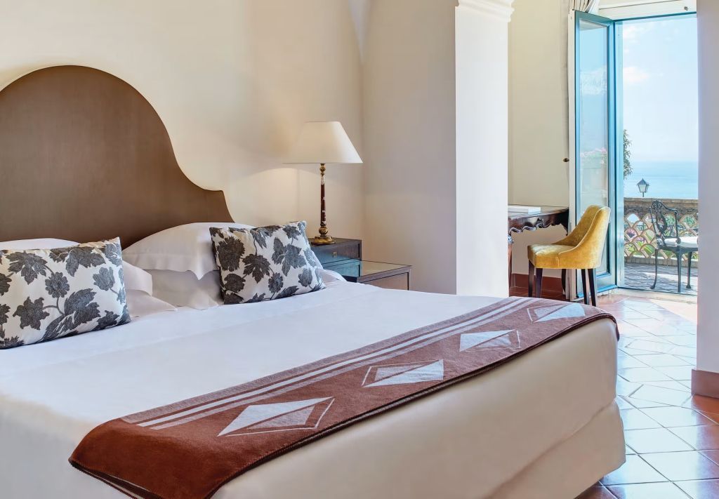 Elegantes Schlafzimmer mit Balkonblick und stilvollen Möbeln