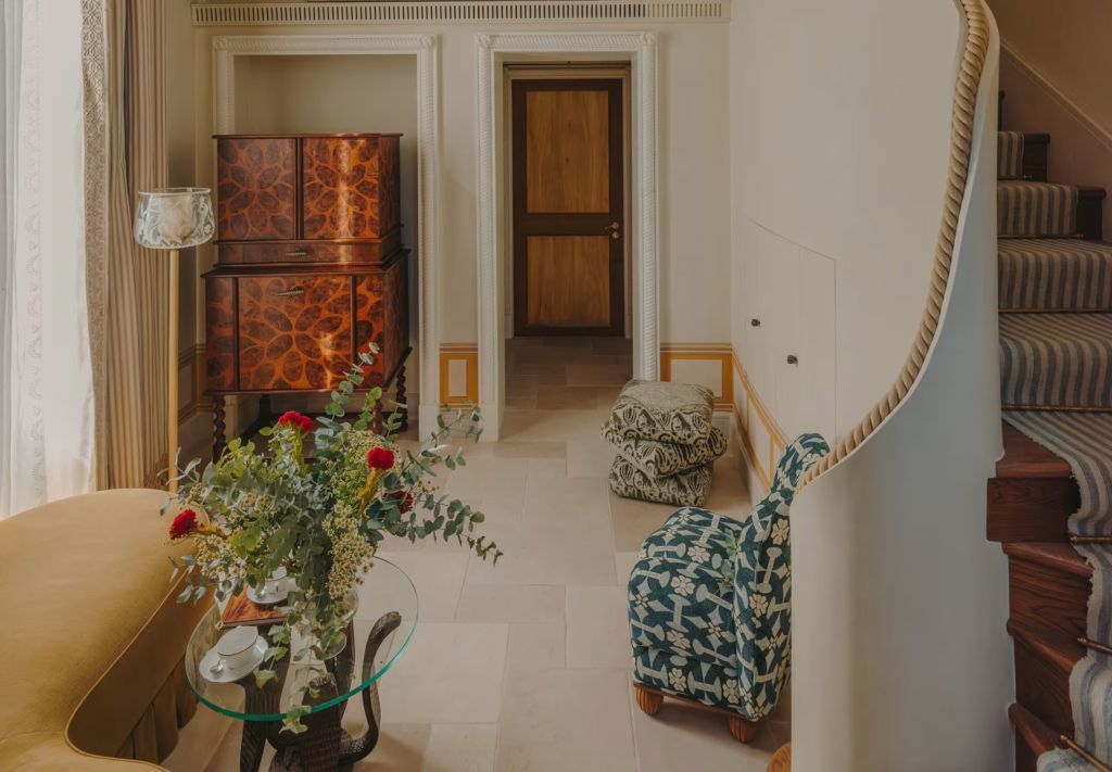 Eleganter Wohnbereich mit floralen Mustern und antiken Möbeln in einer Suite des Grand Hotel Timeo.