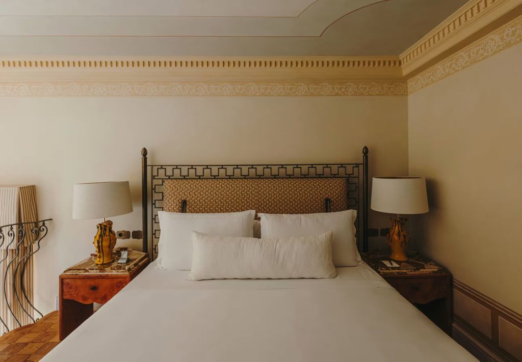Großes Doppelbett mit eleganter Bettwäsche in einer Junior-Suite des Grand Hotel Timeo.