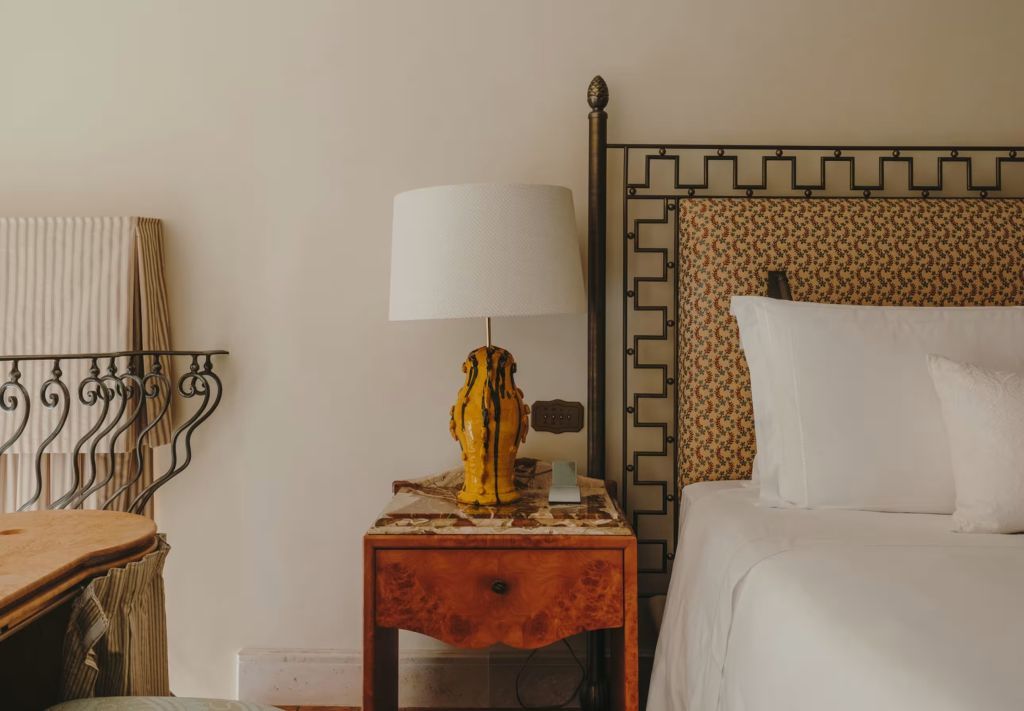 Naheaufnahme eines Nachttisches mit Lampe und Bett in einer Suite des Grand Hotel Timeo.