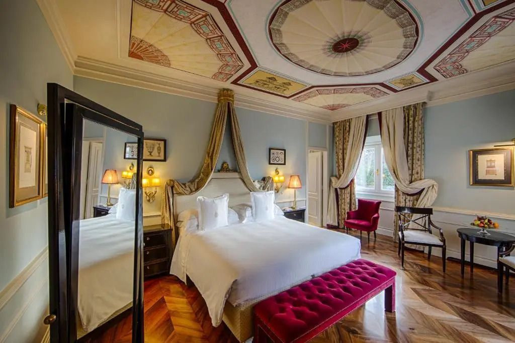 Elegantes Zimmer mit prächtigen Deckenverzierungen und großem Doppelbett.
