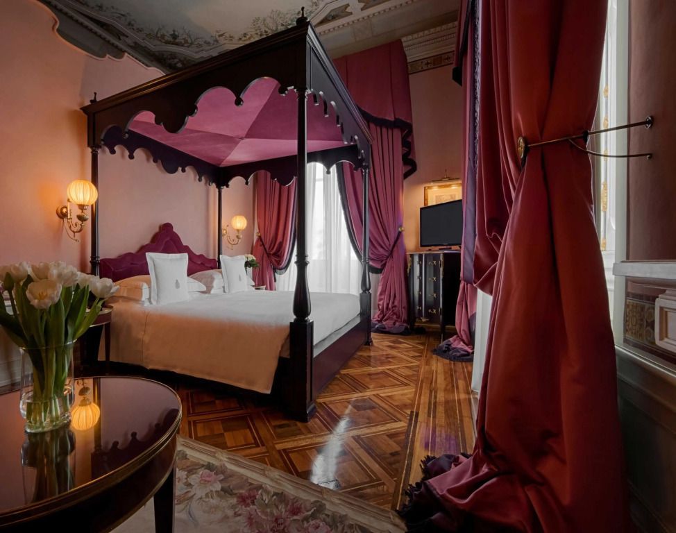 Elegantes Schlafzimmer mit Himmelbett und luxuriösen Vorhängen in der Junior-Suite