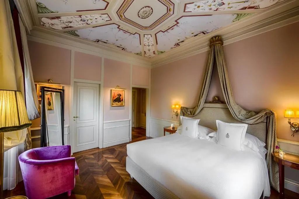 Luxuriöses Doppelzimmer mit aufwendiger Decke und dezenter Wandkunst