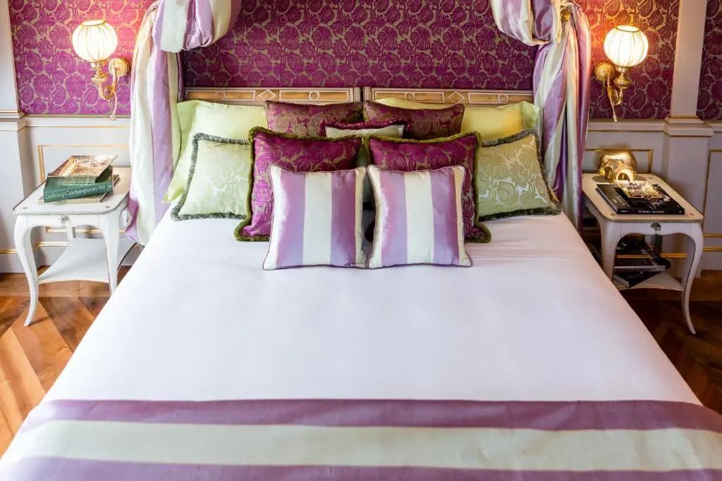 Elegant dekoriertes Bett mit gestreiften und gemusterten Kissen