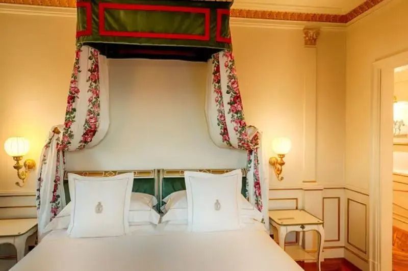 Luxuriöses Doppelbett mit dekorativem Baldachin und weiße Bettwäsche