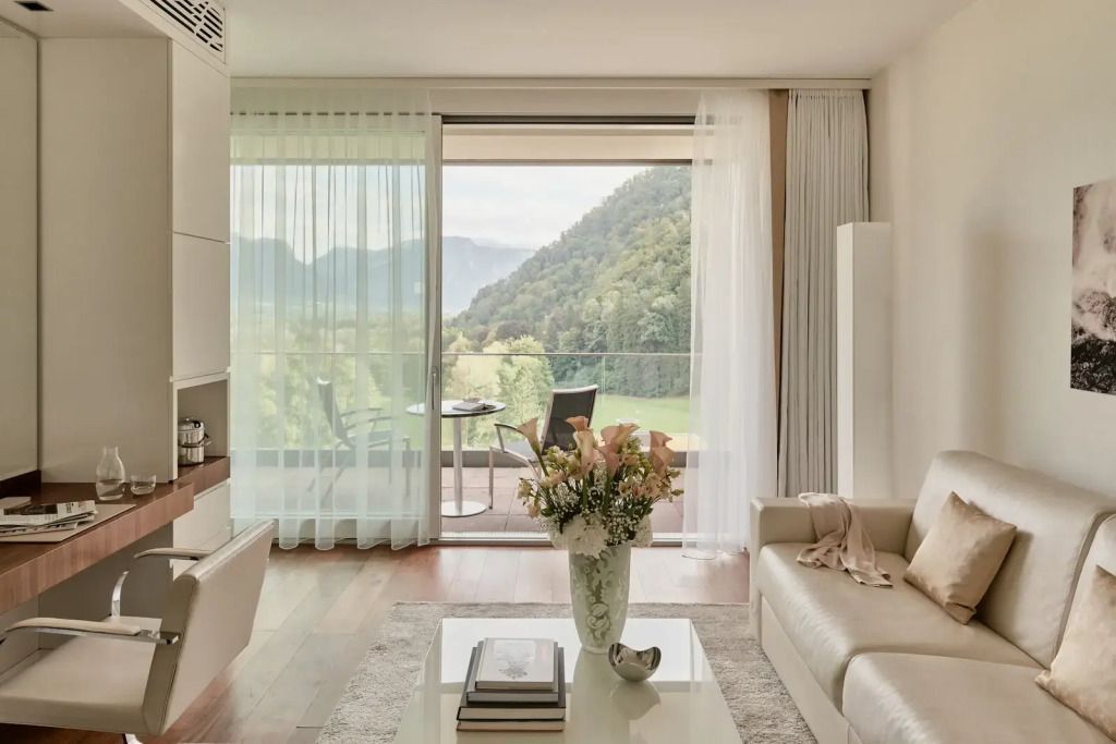 Modernes Wohnzimmer mit Balkontür und Berglandschaft im Hintergrund