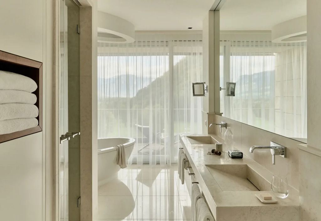 Luxuriöses Badezimmer mit Badewanne und großen Fenstern mit Aussicht