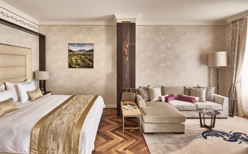 Elegantes Hotelzimmer mit Doppelbett und gemütlicher Sitzgruppe auf Parkettboden
