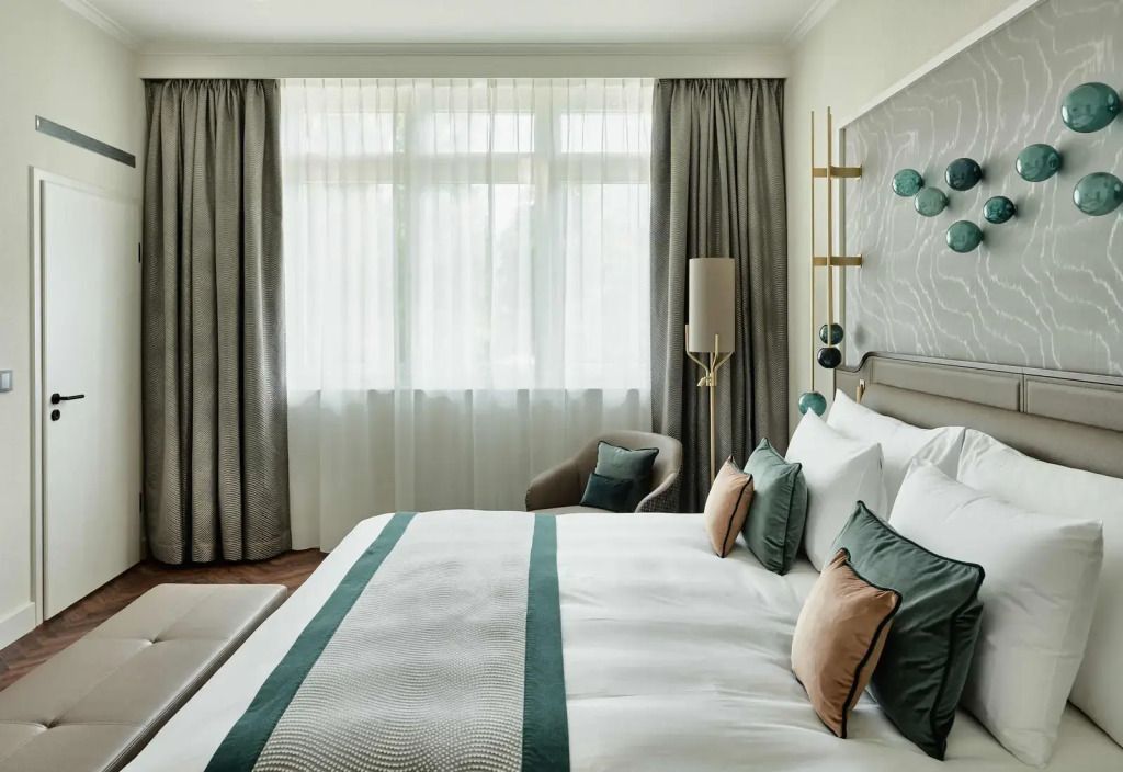 Helles Schlafzimmer mit Doppelbett in der Grand Deluxe Hof Ragaz Suite