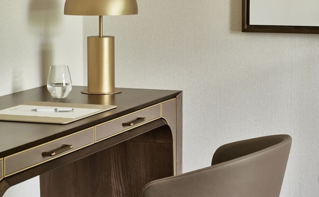 Luxuriöser Schreibtisch mit Lampe und Lederstuhl in der Suite