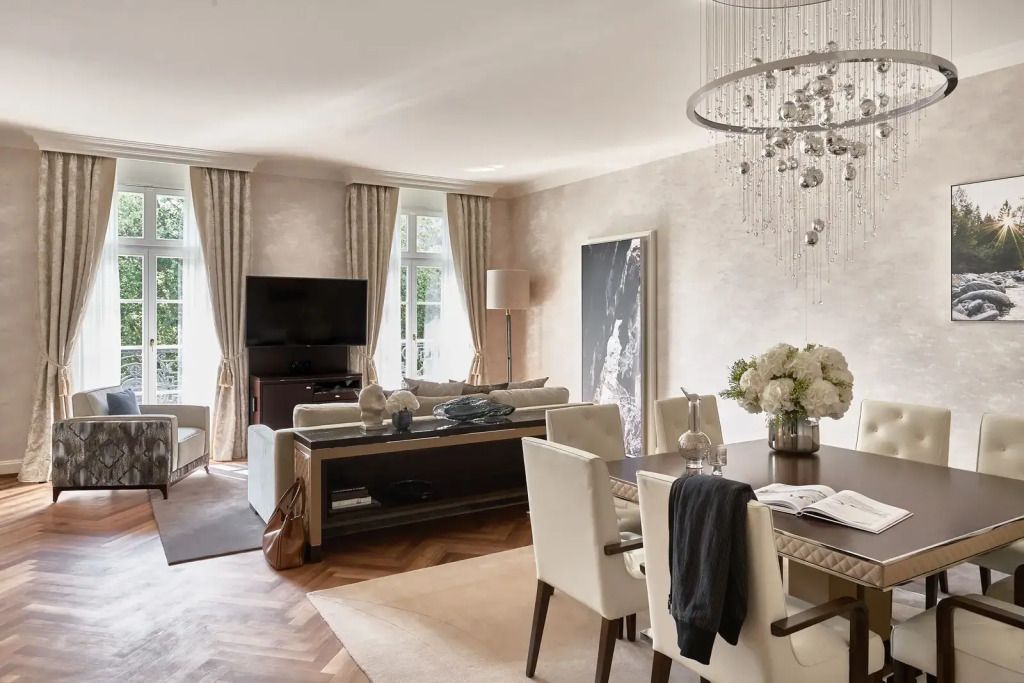 Elegantes Wohnzimmer der Grand Quellenhof Doppel Suite mit Esstisch und Fernseher
