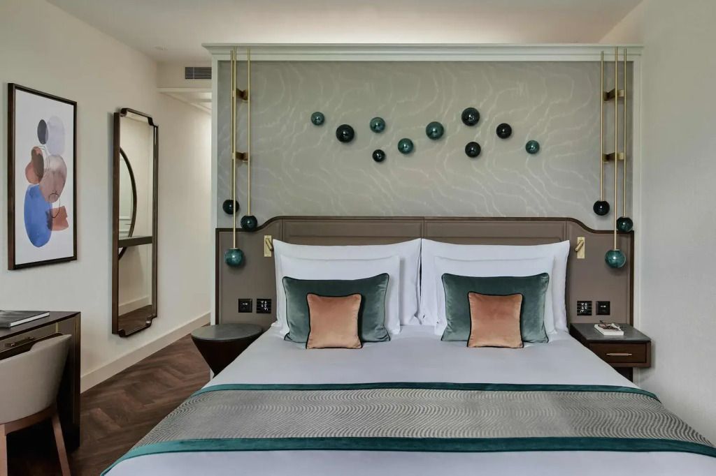 Elegantes Doppelbett im Komfort Hof Ragaz Zimmer mit stilvollen Kissen und Wanddeko