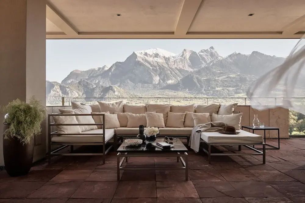 Luxuriöse Terrasse mit bequemer Sitzecke und Blick auf die Alpen