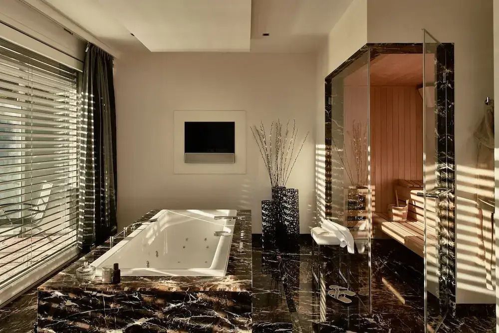 Luxuriöses Badezimmer mit Whirlpool und Sauna in der Penthouse Spa Suite