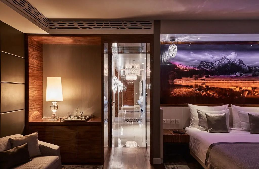 Stilvolles Schlafzimmer mit Glaswand und stimmungsvollem Licht im Grand Resort Bad Ragaz
