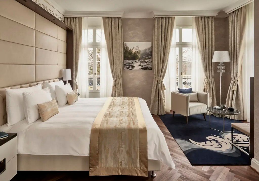 Elegantes Schlafzimmer der Quellenhof Doppel Suite mit großen Fenstern und edlem Dekor