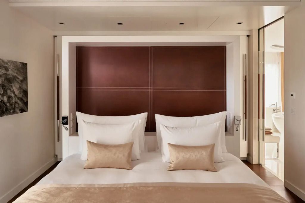 Luxuriöses Doppelbett mit eleganter Bettwäsche und Lederkopfteils in der Spa Doppel Suite