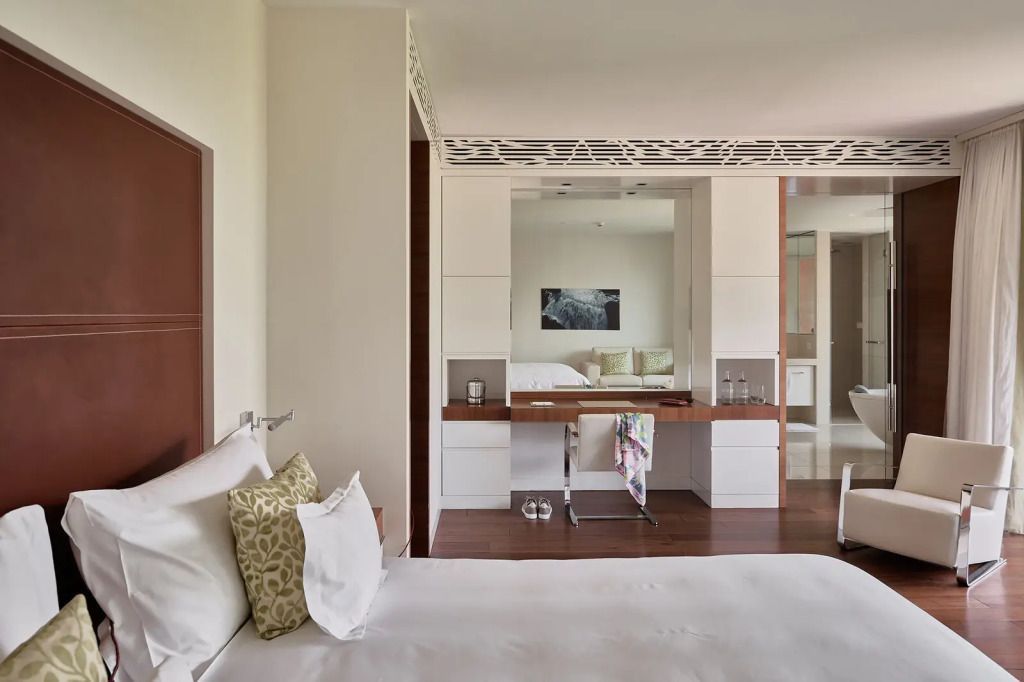 Elegantes Hotelzimmer mit Doppelbett und Schreibtischspiegel in moderner Einrichtung
