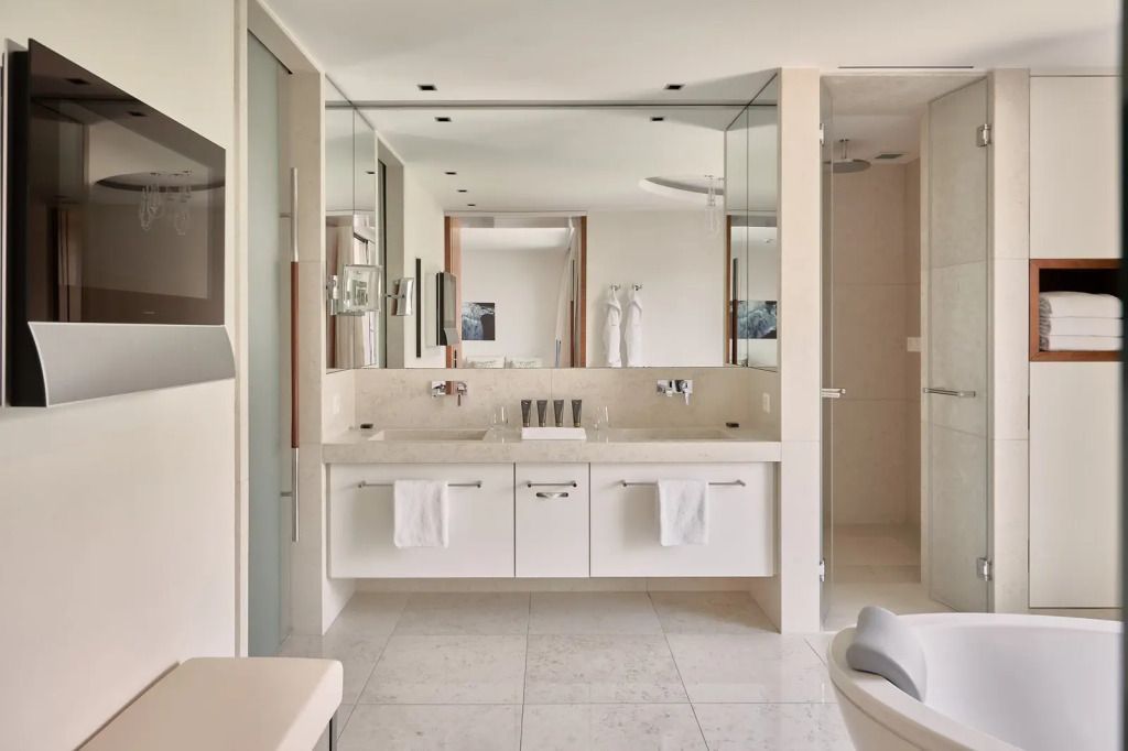 Badezimmer mit Doppelwaschbecken, großem Spiegel und eleganten Armaturen